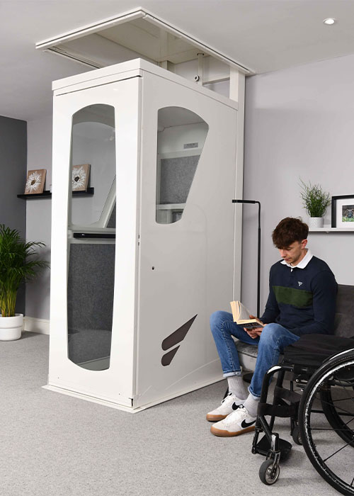 through floor wheelchair lift a man sitting beside a through floor wheelchair lift